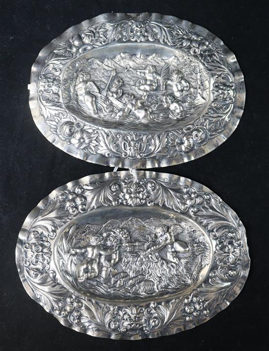 A pair of late 18th century Augsburg small silver oval plaques, embossed with cherubs, masks and foliage, with Austrian import marks,